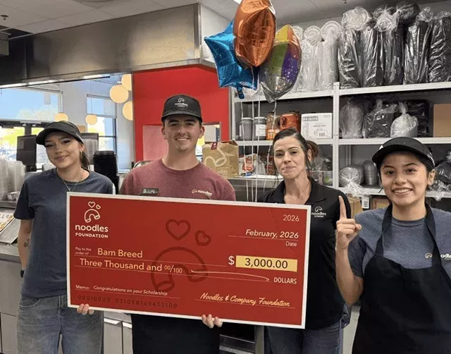 Noodles Foundation winner holding the $3,000 check with family