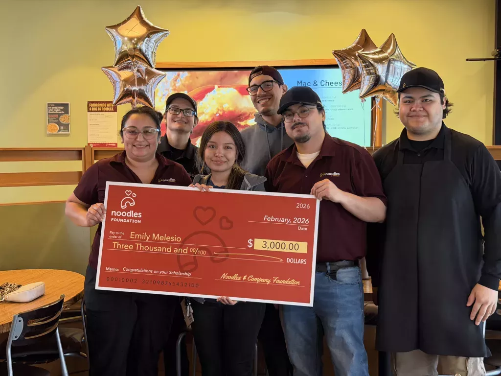 Noodles Foundation winner holding the $3,000 check with family