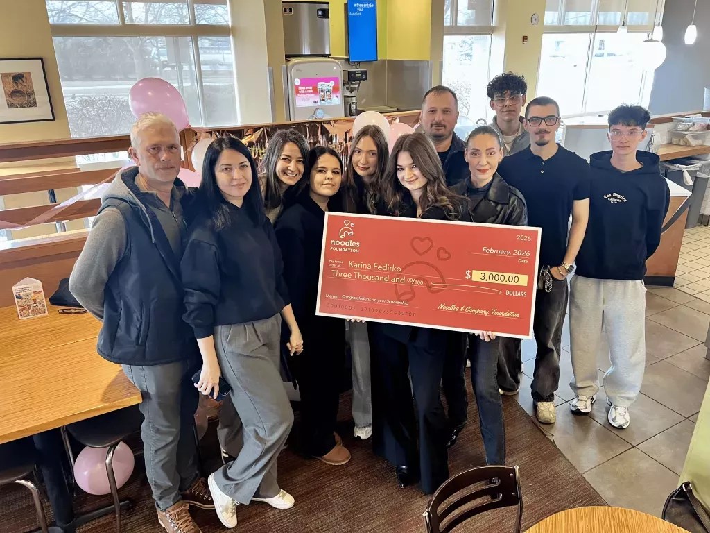 Noodles Foundation winner holding the $3,000 check with family